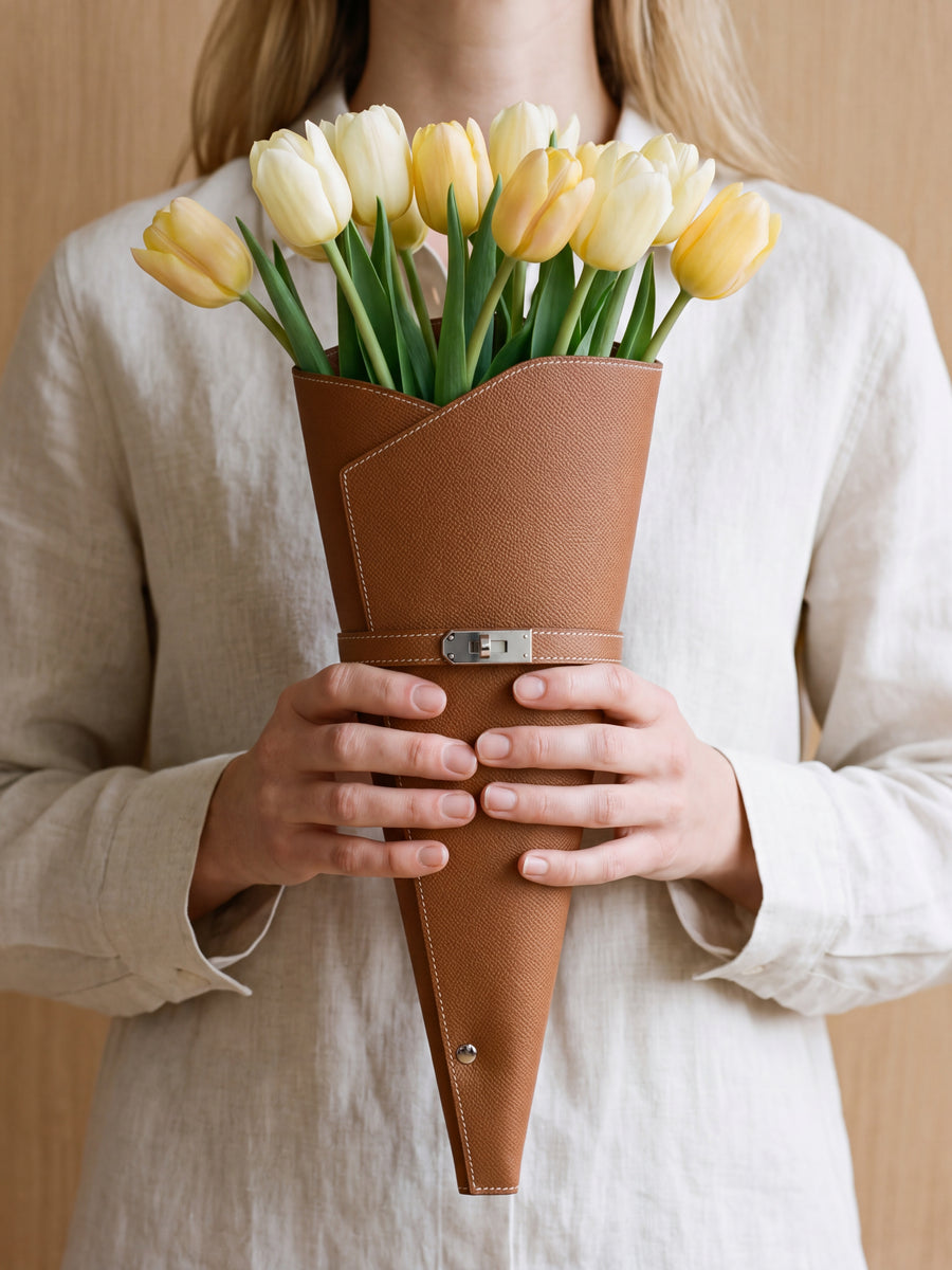 Vrouw op straat met een cognac bloemenkoker en veldbloemen