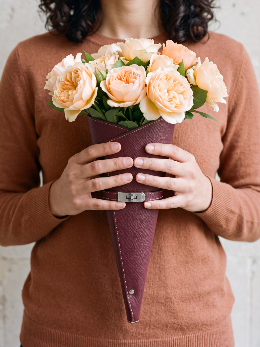 Vrouw met een bordeaux bloemenkoker en witte rozen
